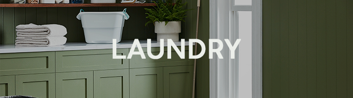 Laundry room with green interior theme, featuring a counter with towels and laundry items.