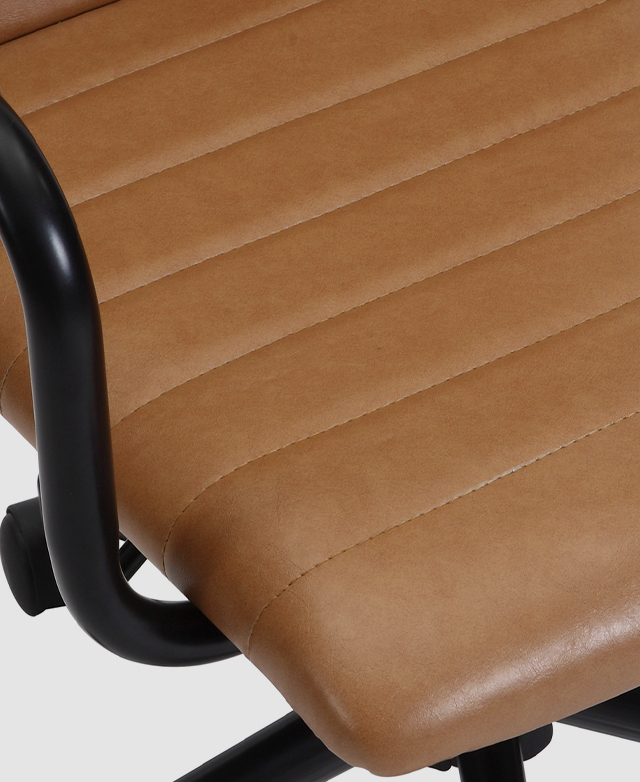 Close-up of the seat shows the smooth and slightly aged appearance of its microfibre faux leather upholstery. Close-up of the seat shows the smooth and slightly aged appearance of its microfibre faux leather upholstery.