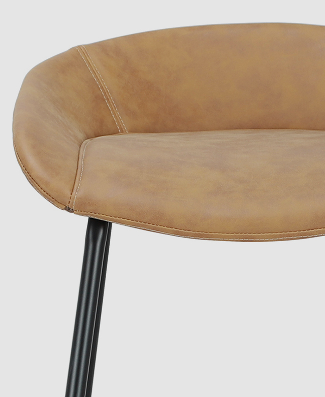 Front-on view of the faux leather seat, displaying its slightly worn look and detailed stitching.