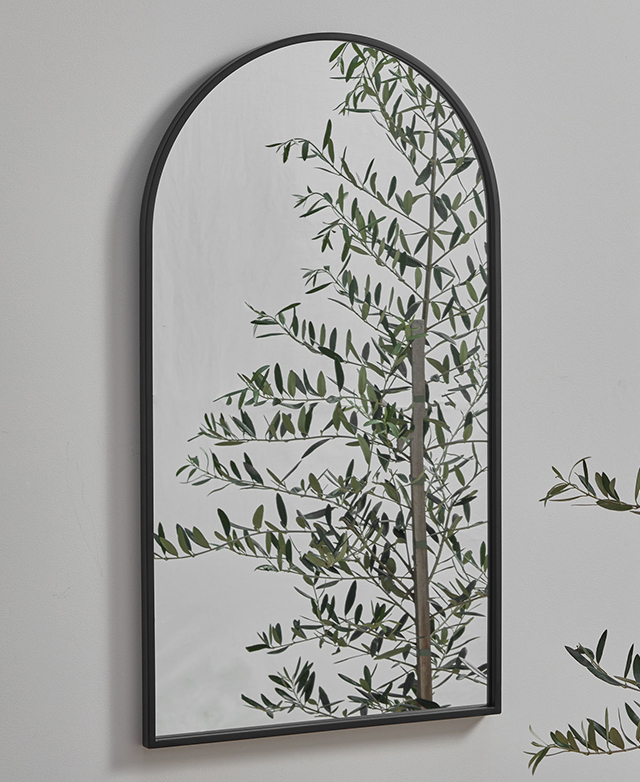 The arched mirror reflects an olive tree, giving a natural impression of light.
