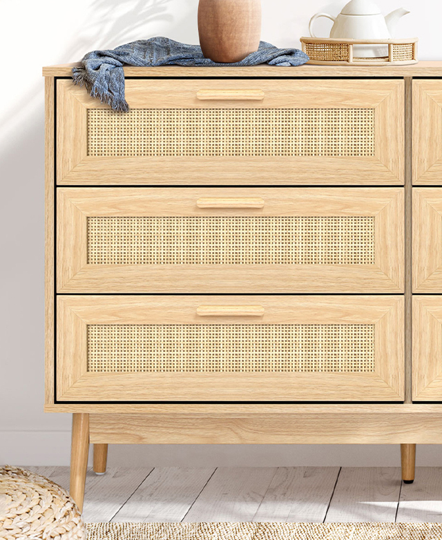Cropped to highlight one end and three drawers, plus a teapot, tray, vase and teatowel on top.