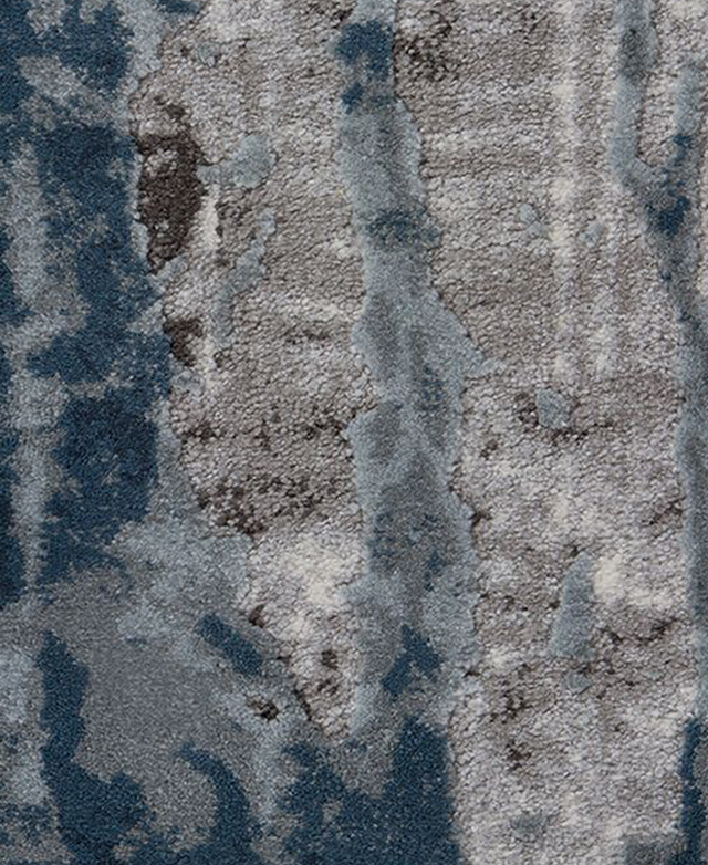 The rug features a short pile and abstract colour pattern consisting of blue, grey, and charcoal. The rug features a short pile and abstract colour pattern consisting of blue, grey, and charcoal.