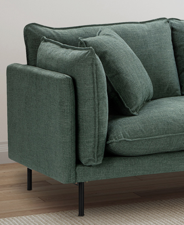 One end of an ocean-green sofa. The sofa frame is narrow; the seat, back, and accent cushions are plump. One end of an ocean-green sofa. The sofa frame is narrow; the seat, back, and accent cushions are plump.