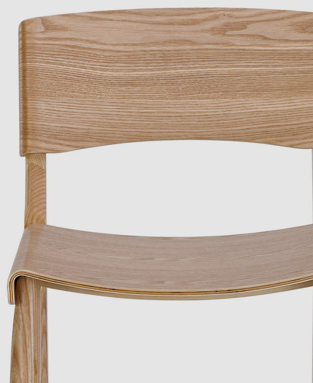 A bentwood chair seat shown from front on. Made of solid ash, it has a light blonde hue and natural wood grain texture.
