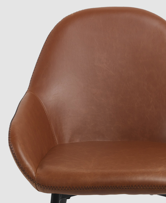 Shown from front on, the slightly distressed texture of the chair's PU leather upholstery gives it an aged appearance. Shown from front on, the slightly distressed texture of the chair's PU leather upholstery gives it an aged appearance.