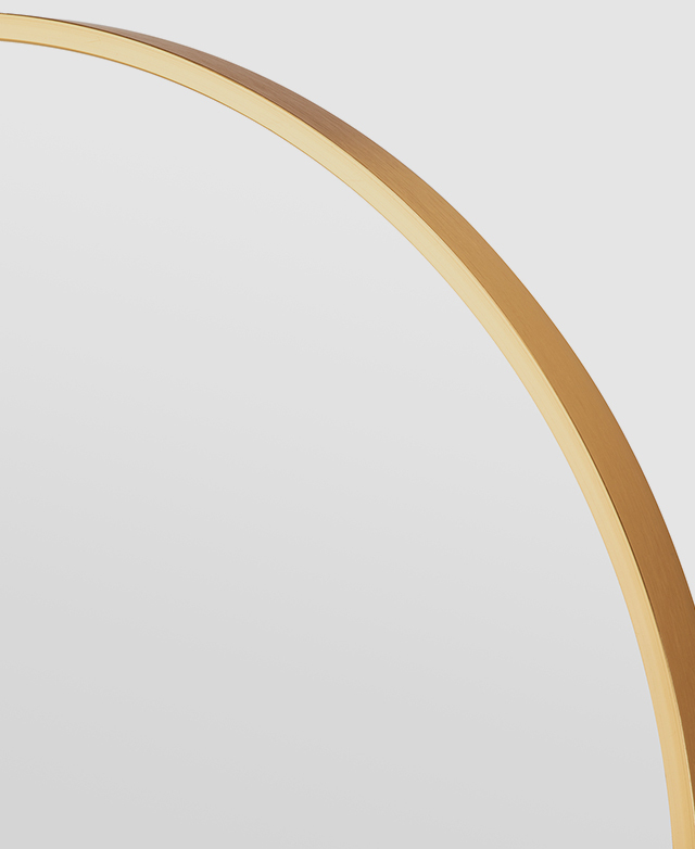 A rounded edge of a slender gold aluminium mirror frame.