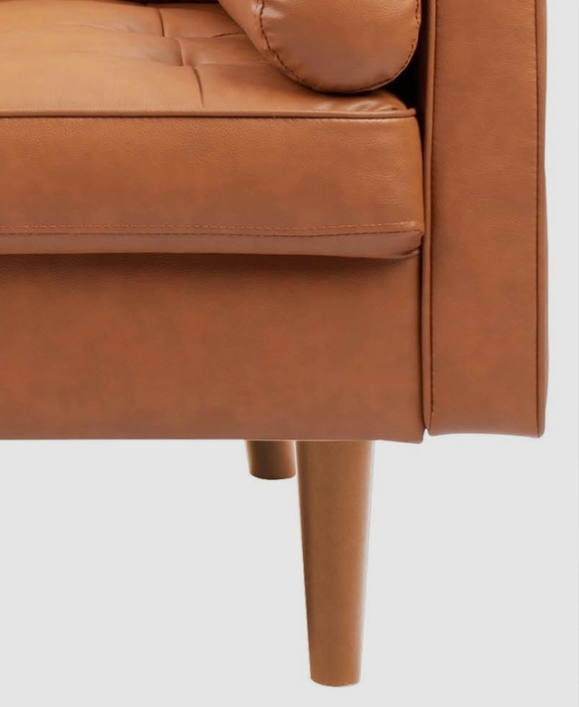 Tapered eucalyptus wood legs underneath the blocky body of the chair elevate it slightly off of the floor. Tapered eucalyptus wood legs underneath the blocky body of the chair elevate it slightly off of the floor.