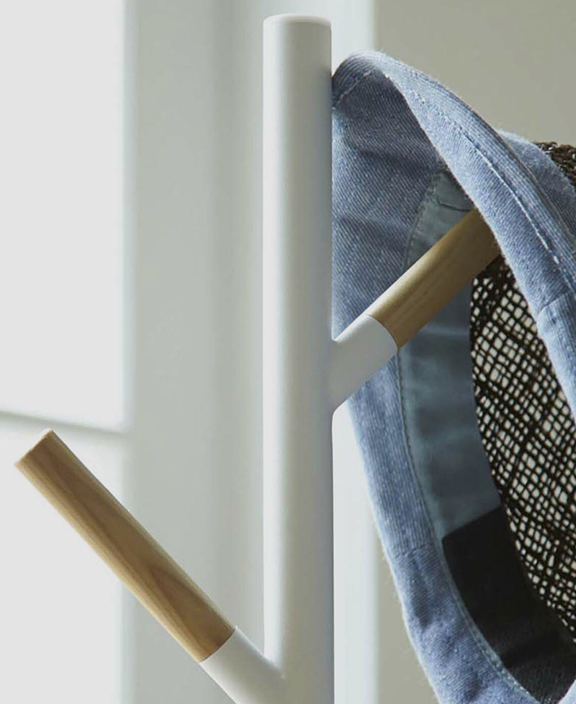 Zooming in on the top of the hat stand shows its white steel stand and solid teak wood hanger arms.