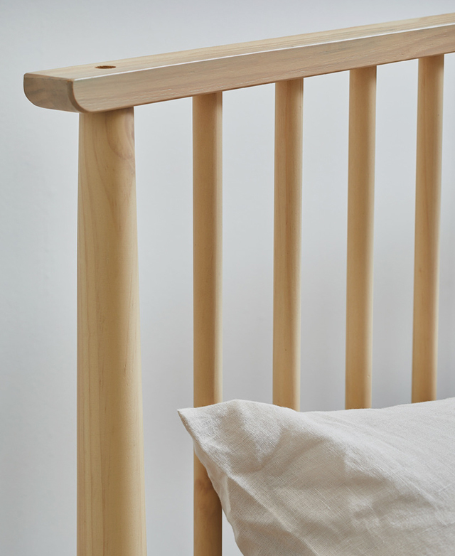 The washed pine wood spindle bedhead is in focus.