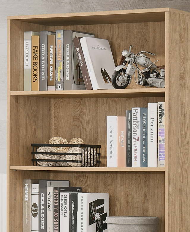 An assortment of books and decor are arranged on each shelf of a wooden bookcase.