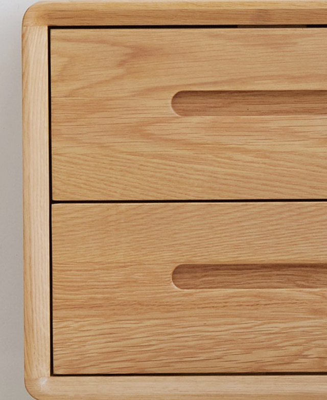 The body of the small bedside table is in focus, highlighting the typically straight wood grain texture of solid oak. The body of the small bedside table is in focus, highlighting the typically straight wood grain texture of solid oak.