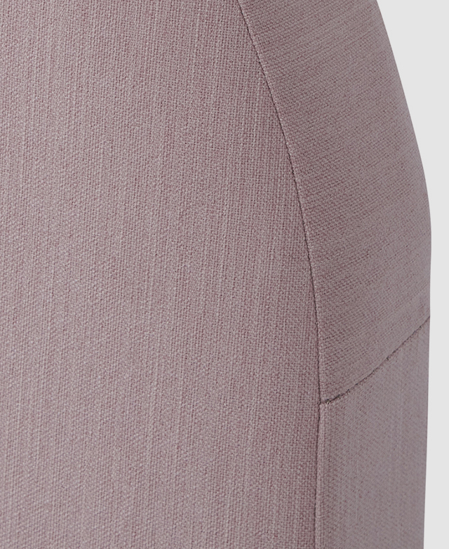 Close-up of the soft pink polyester upholstery wrapped around the arching bedhead.