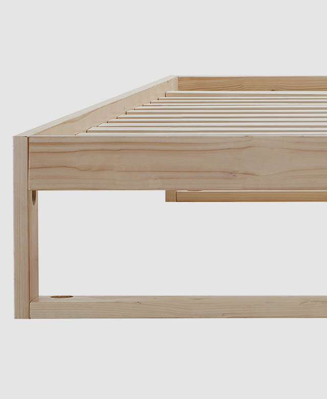 Close-up of a solid pine bed base highlights its typically straight wood grain texture.
