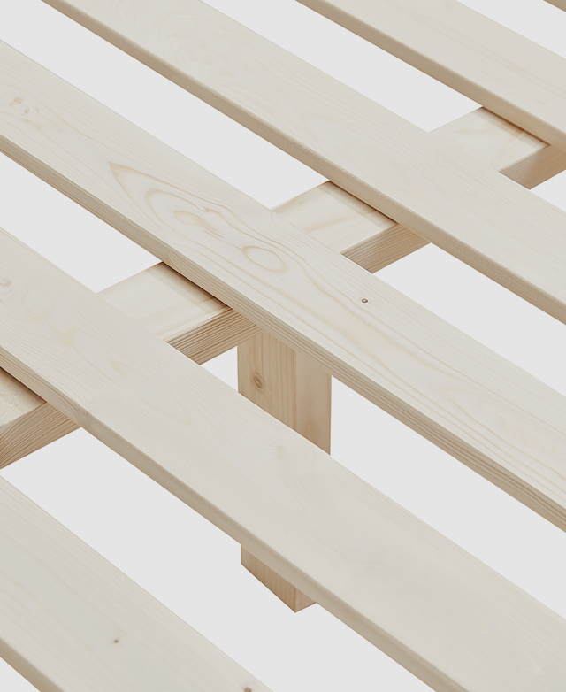 Large-scale view of flat pine wood slats that are evenly spaced apart, with a central support beam underneath.