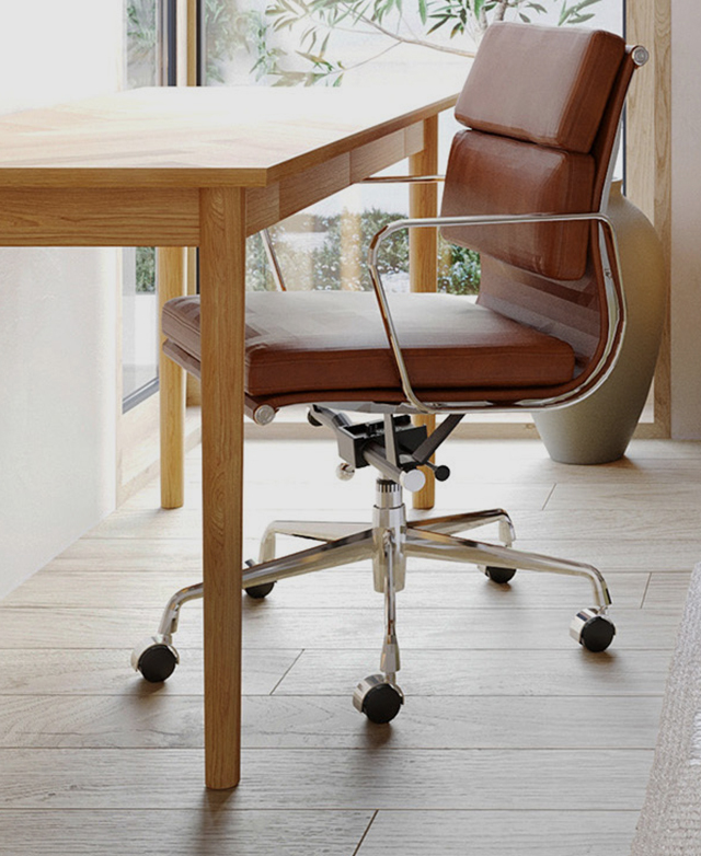 A tan leather Eames replica chair and a minimalist timber office desk.