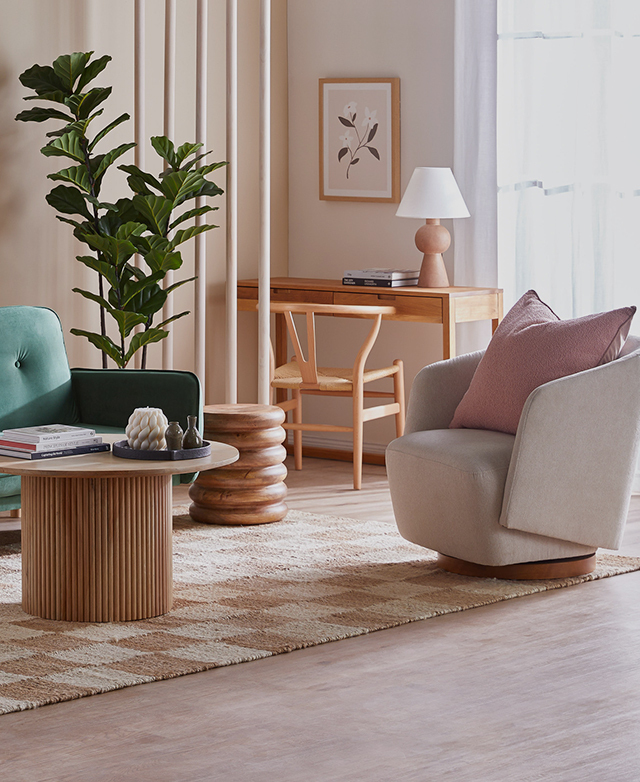 A cream-coloured accent chair is styled in a sun-filled living room space. A cream-coloured accent chair is styled in a sun-filled living room space.