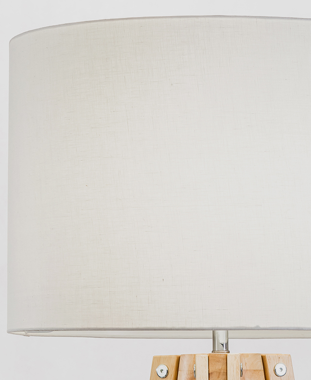 A white jute lamp shade is in focus, highlighting its natural soft tonal markings. A white jute lamp shade is in focus, highlighting its natural soft tonal markings.