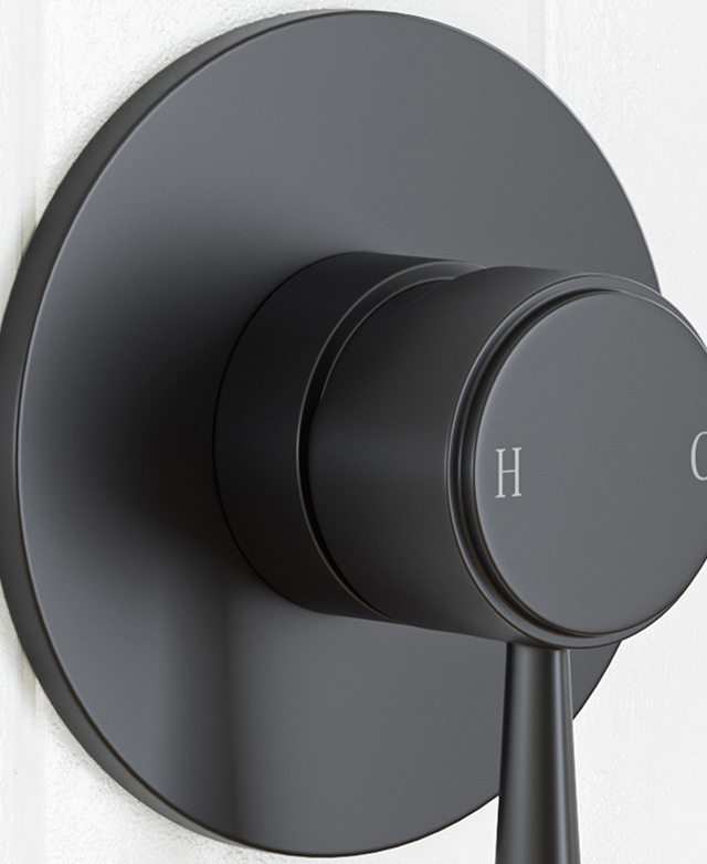 Traditional style shower mixer in matte black mounted on a white tile wall Traditional style shower mixer in matte black mounted on a white tile wall
