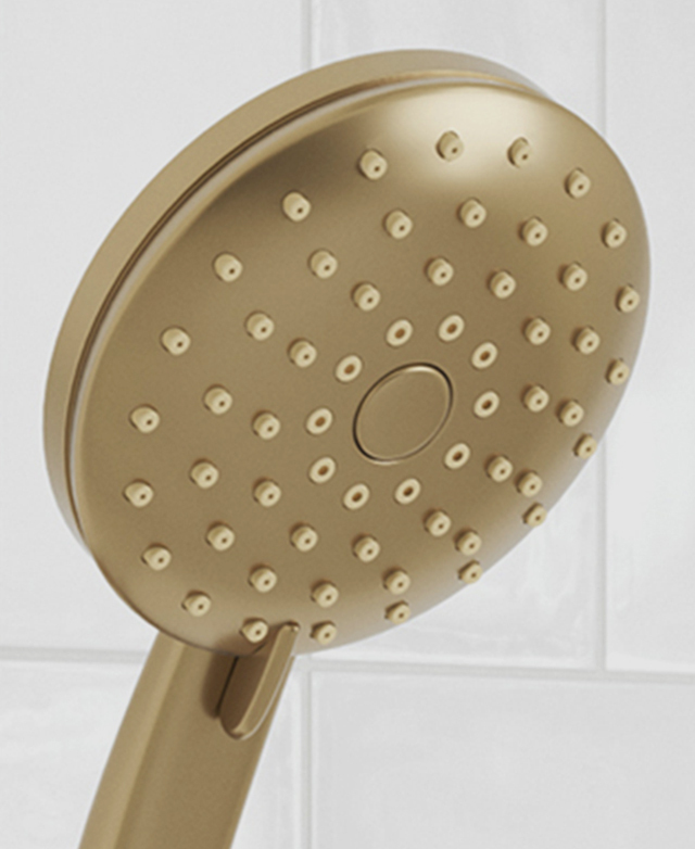 Round brushed gold shower hand piece close up of shower nozzle pattern and the lever for water pattern selecting Round brushed gold shower hand piece close up of shower nozzle pattern and the lever for water pattern selecting