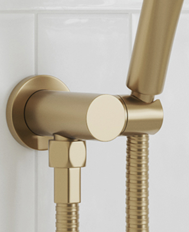 wall mounted brushed gold shower hand piece bracket close up showing the PVD finish with a white tile background wall mounted brushed gold shower hand piece bracket close up showing the PVD finish with a white tile background