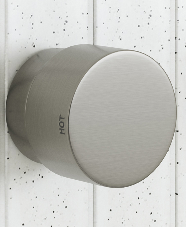 wall mounted brushed nickel dial style tapware showing the hot indicator on the dial with a speckled tile background wall mounted brushed nickel dial style tapware showing the hot indicator on the dial with a speckled tile background