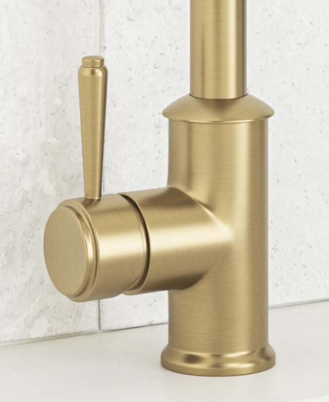 Base of stanwell brushed gold sink mixer with lever mounted on benchtop before a tiled wall