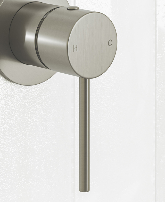 Close-up of the brushed nickel shower/bath wall mixer with pin lever against a white tiled wall