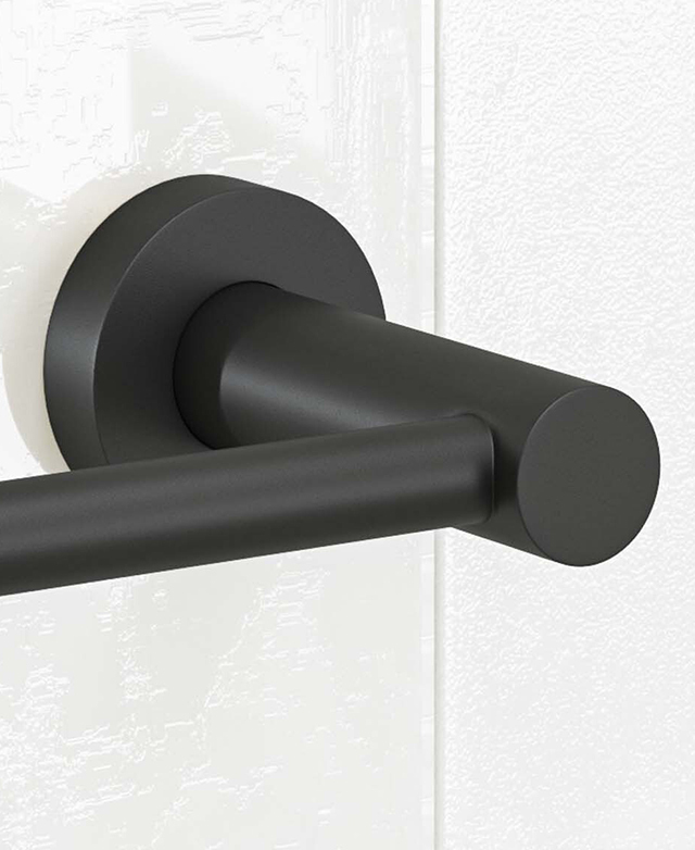 Close-up of the clovelly matte black round backplate, with base and part of the holder mounted on white tiled wall