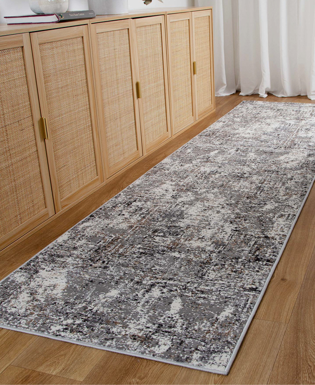 The 0.8cm pile height and thick, grey serged edge of the rug shown from up close. The 0.8cm pile height and thick, grey serged edge of the rug shown from up close.