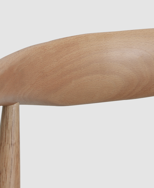 Close up of the light-toned rubberwood dining chair frame and its smooth finishes.