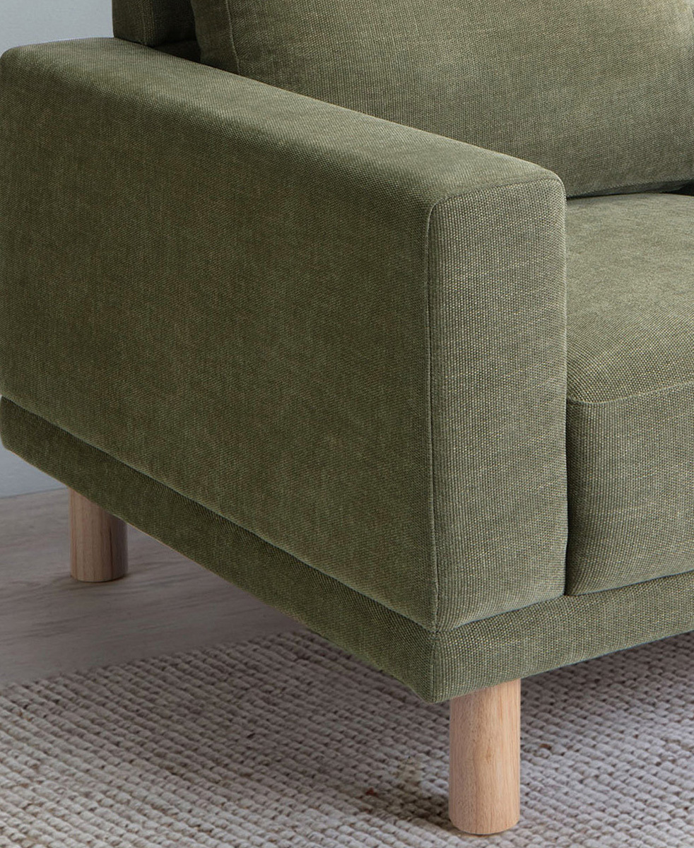 Cropped view shows a corner of the armchair on top of a cream rug.