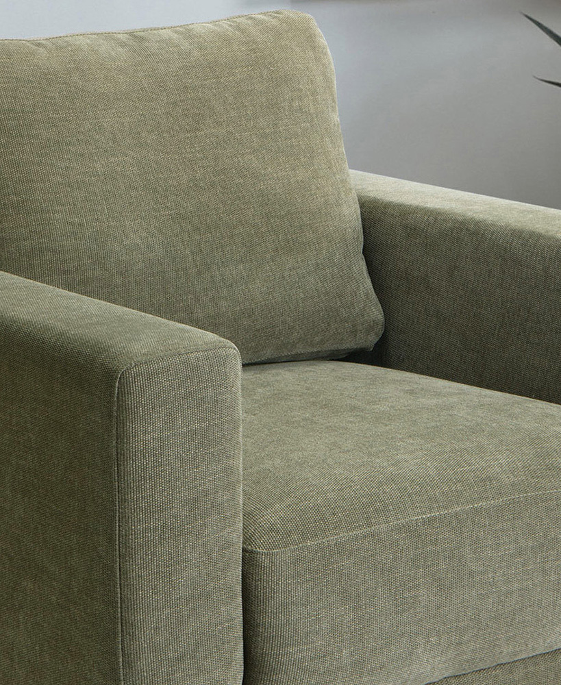 The generous depth of the seat of the green armchair is in the frame.
