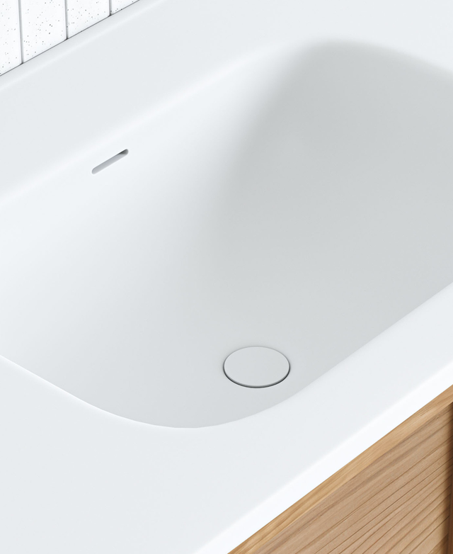 The top-down angle highlights the smooth integration of the soft rectangular sink within the vanity top, all in crisp white. The top-down angle highlights the smooth integration of the soft rectangular sink within the vanity top, all in crisp white.