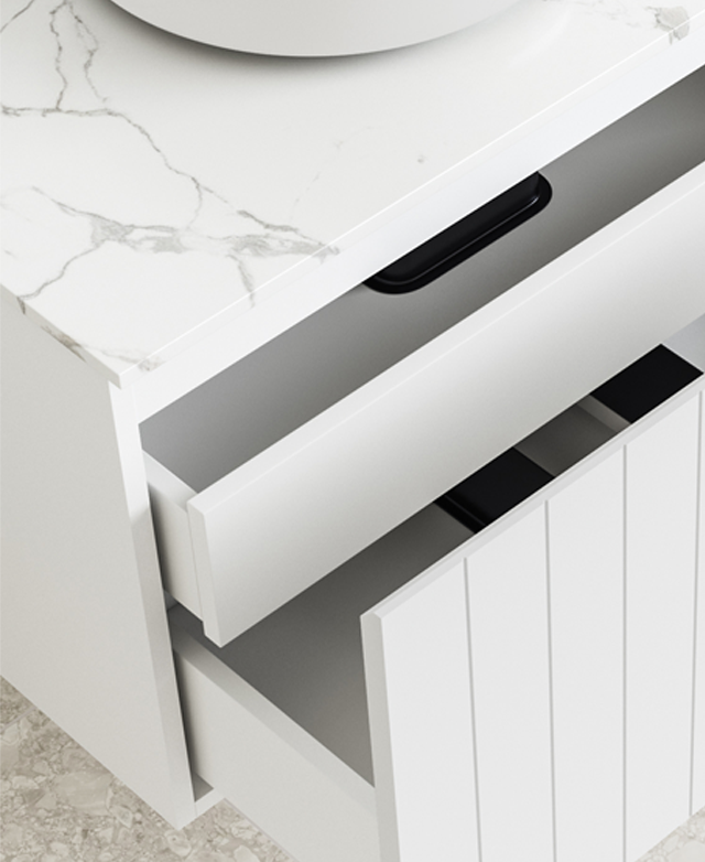 A high three-quarter view shows the open drawers and the soft grey veining detail of the white stone top.