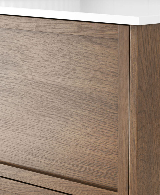 Close-up of a modern timber cabinet with handleless drawers, wood grain and white top.