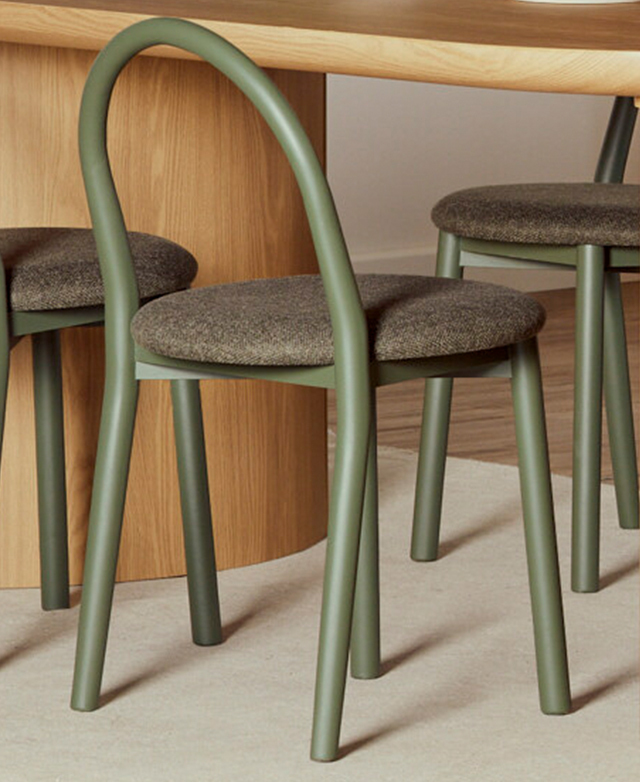 The arch-shaped backrest and frame is captured from behind, and the white upholstered round seat pops in a dark environment.