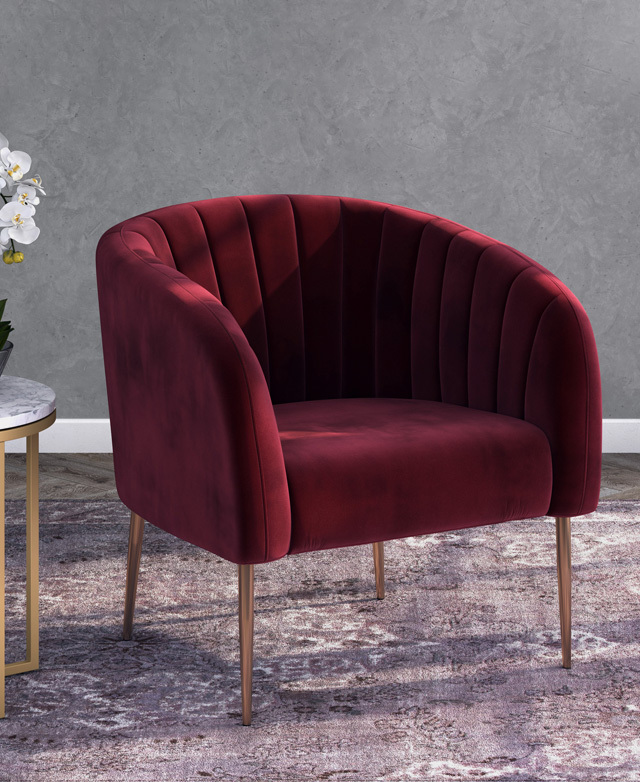 The burgundy armchair is positioned on a purple-toned rug, in front of a grey wall, in a room with soft, romantic lighting.