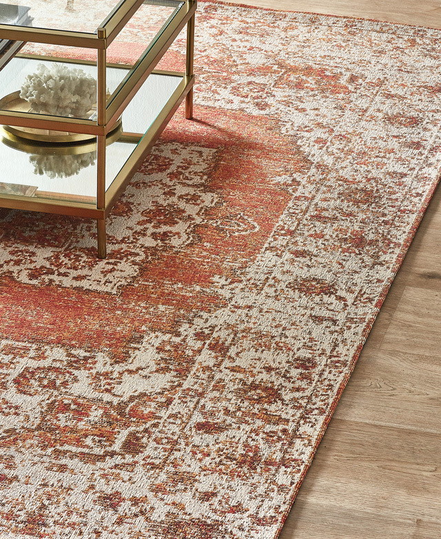 Bird's-eye angle of the distressed rug styled on timber flooring and under a gold-framed coffee table in a living room. Bird's-eye angle of the distressed rug styled on timber flooring and under a gold-framed coffee table in a living room.