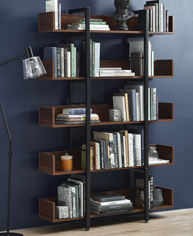 Books upright and horizontal adorn the shelves from top to bottom. An adjustable floor lamp is positioned next to it. Books upright and horizontal adorn the shelves from top to bottom. An adjustable floor lamp is positioned next to it.