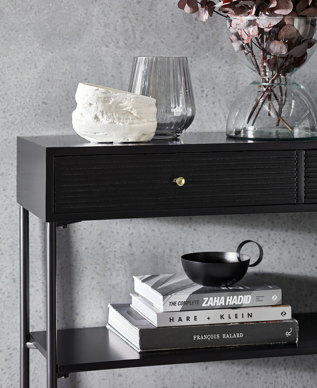 A monochrome setting presents cool tones. The top surface & lower shelf are styled with books, organic ceramics & glassware.