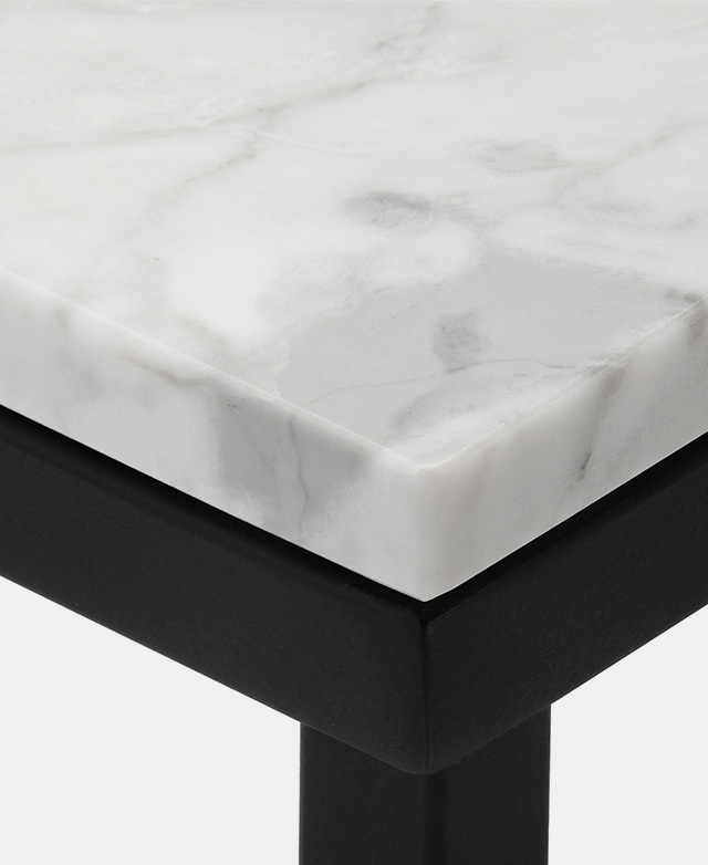 A close-up image of the corner of the table highlights the beautiful grey veins atop the sharp black base.