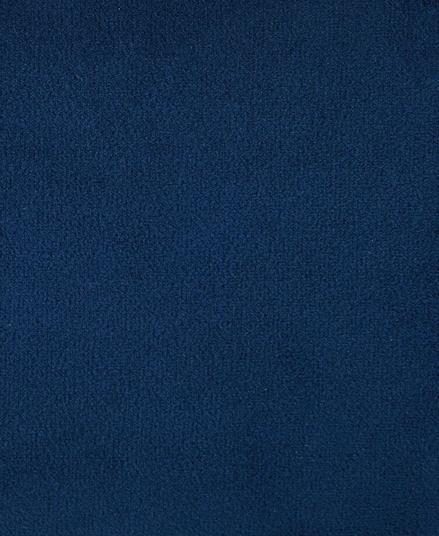 The smooth nap of 100% polyester velvet fabric in a blue colour is in focus.