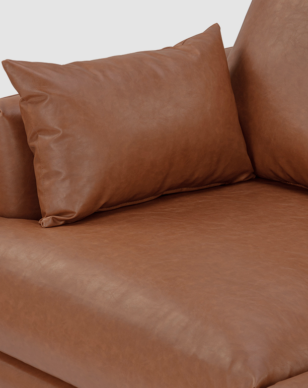 Tan faux leather upholstery features a slightly aged texture and is padded with plush cushioning. Tan faux leather upholstery features a slightly aged texture and is padded with plush cushioning.