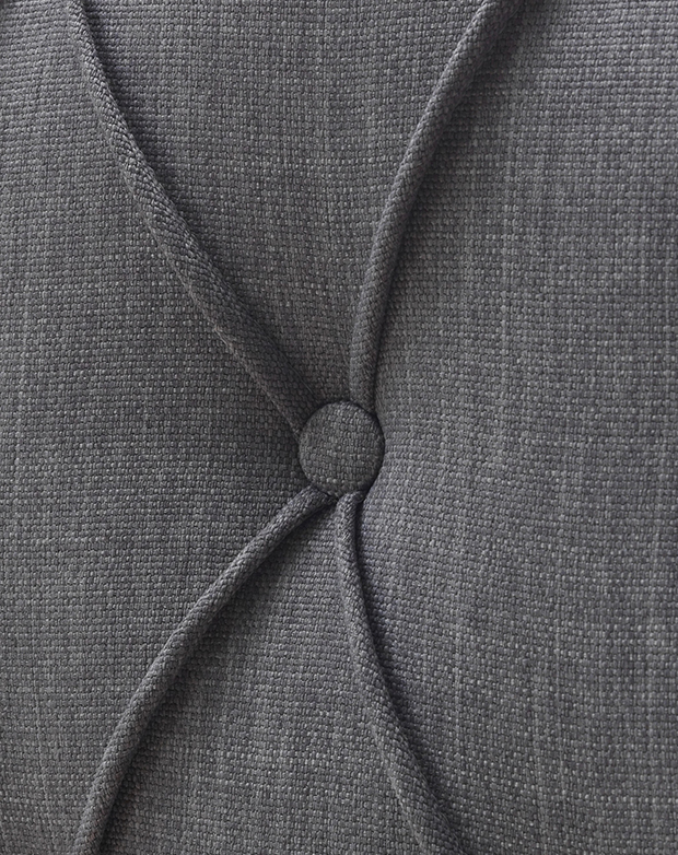 Magnified detail of the pleating that forms a diamond shape around a tufted button.