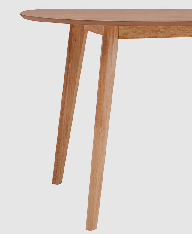 At eye level, the table's smooth, tapered rubberwood legs are in focus. At eye level, the table's smooth, tapered rubberwood legs are in focus.