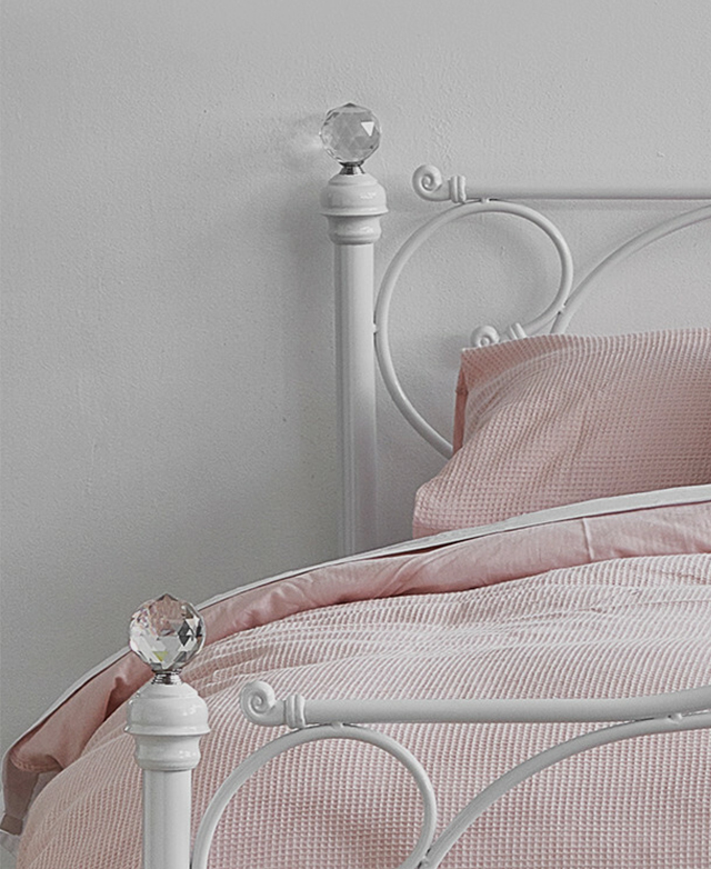 A close-up of one side of the bed shows the faceted crystal ball finials on top of each corner of the bed posts. A close-up of one side of the bed shows the faceted crystal ball finials on top of each corner of the bed posts.