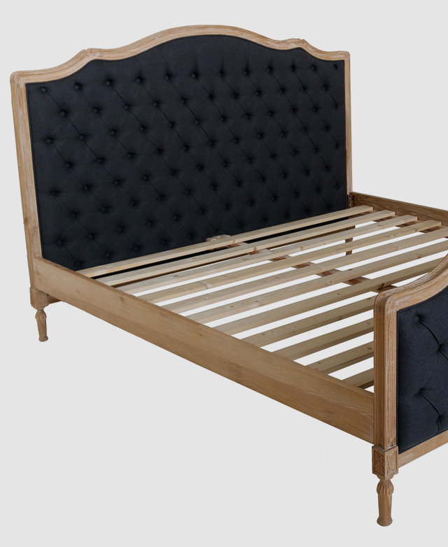 Three-quarter angle of a bed frame in white washed solid oak. Flat horizontal timber slats are in the centre. Three-quarter angle of a bed frame in white washed solid oak. Flat horizontal timber slats are in the centre.