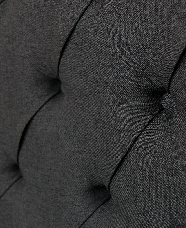Close-up of button tufting in a diamond pleat pattern that appears on the bedhead and the footboard. Close-up of button tufting in a diamond pleat pattern that appears on the bedhead and the footboard.