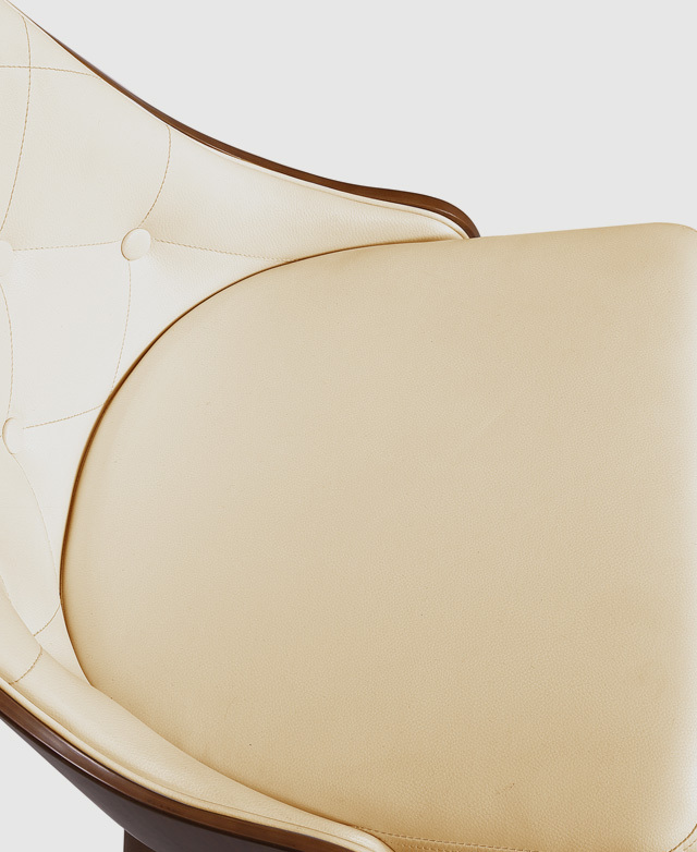 Bird's-eye view of the spacious seat cushion of a white faux leather dining chair.