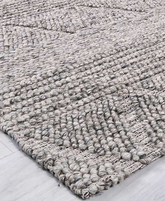 The high-low texture of the rug is shown close up, and the geometric pattern is on display.